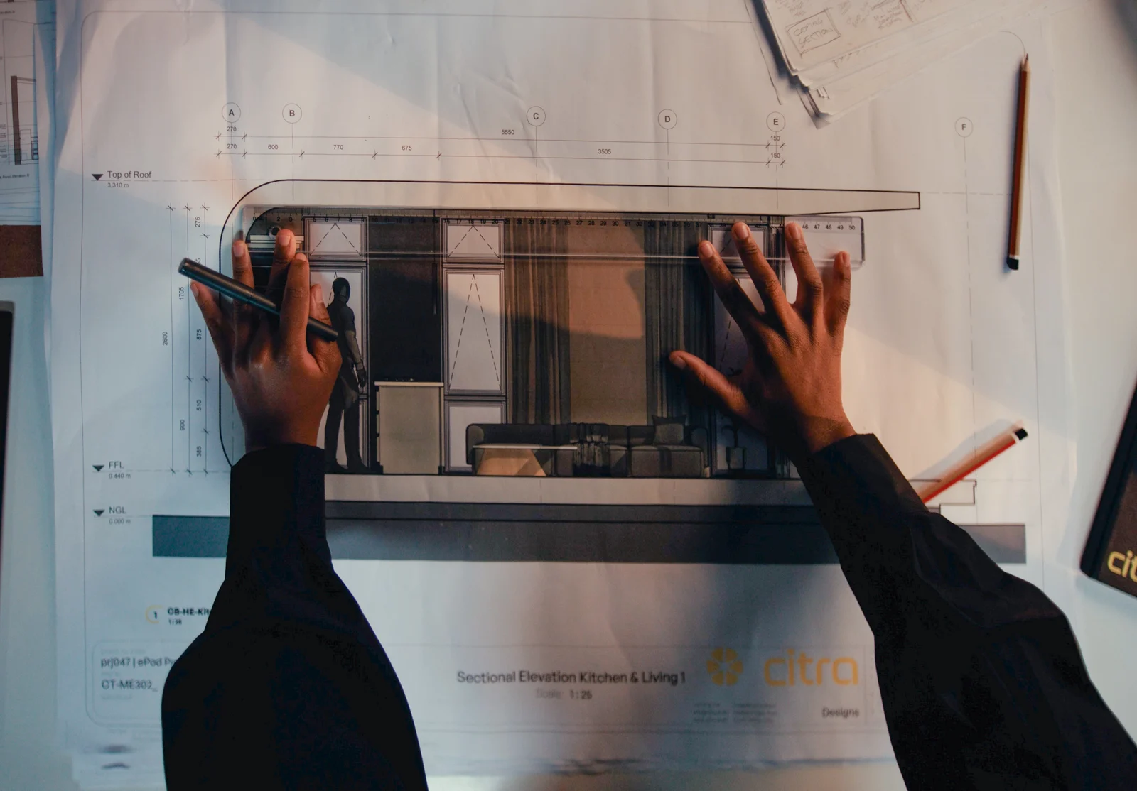 Hands working over architectural plans