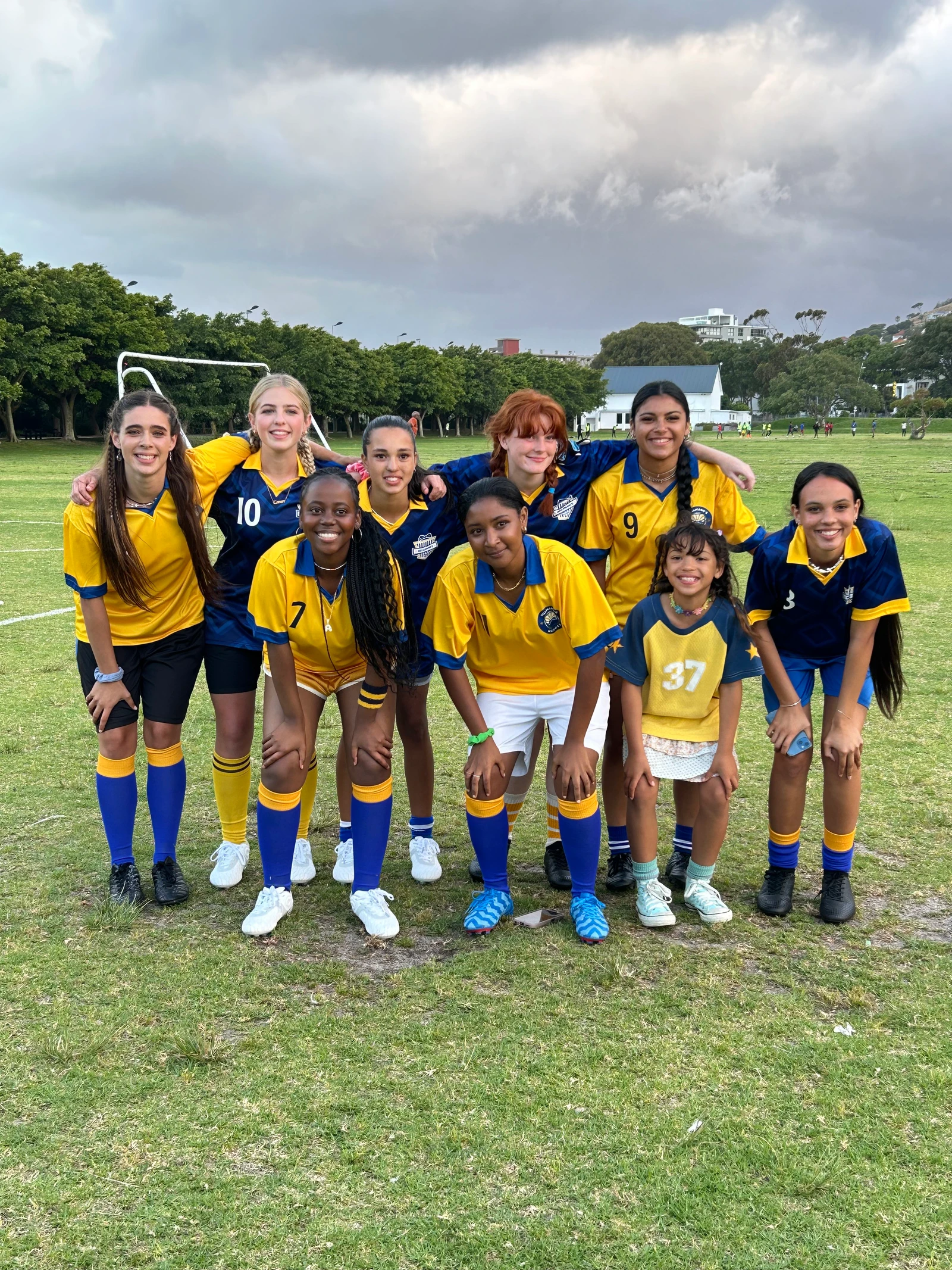 Football cast in blue and yellow jerseys on location