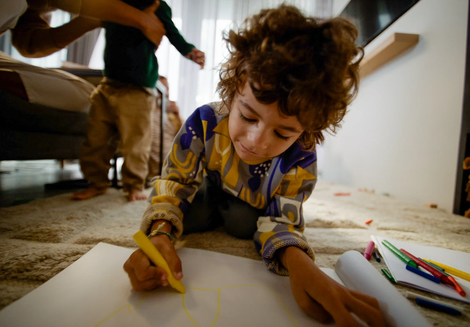 A child drawing a dream home on paper.